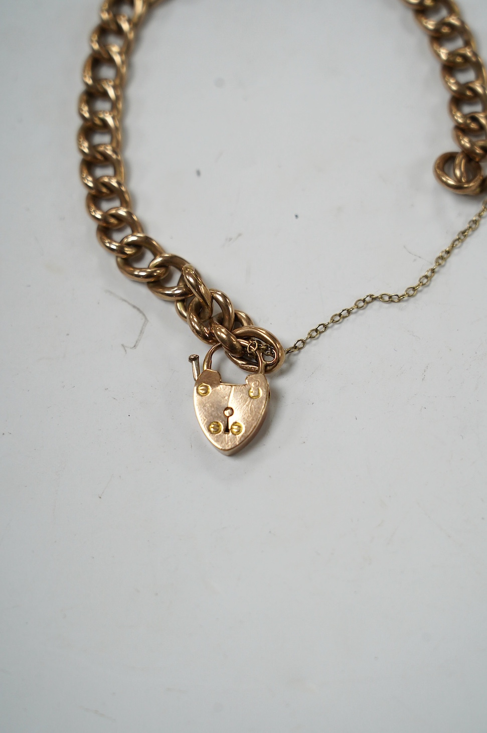 An early 20th century 9ct curb link bracelet, with heart shaped padlock clasp, 18cm, 13.6 grams. Condition - fair